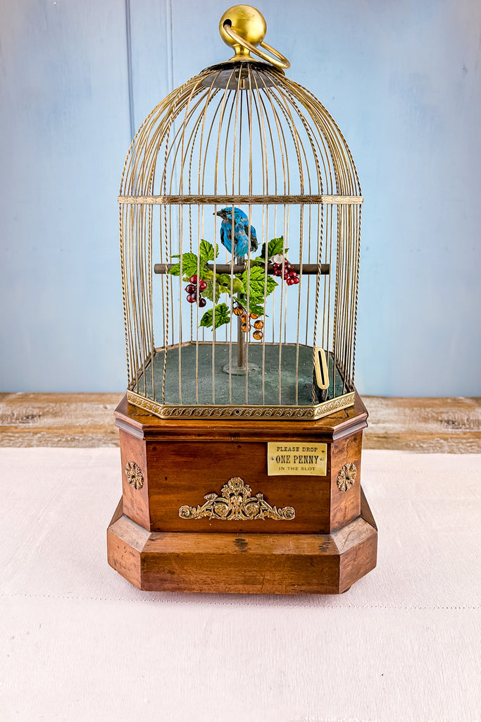 An antique bird cage with feeder bowls - brass, glass, porcelain
